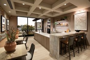 Marana apartment for rent - A modern kitchen with a bar area and a dining table with chairs.