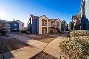 Tucson apartment for rent - A sunny day in a residential area with apartment buildings and a sidewalk.