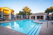 Tucson apartment for rent - A swimming pool surrounded by a fence and chairs.