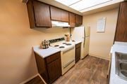 Tucson apartment for rent - A kitchen with a stove, refrigerator, and wooden cabinets.