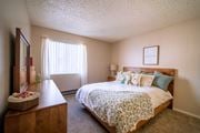 Tucson apartment for rent - A bedroom with a bed, nightstand, and a window with blinds.