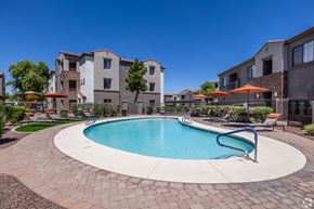 Queen Creek apartment for rent - A swimming pool surrounded by a brick patio and lounge chairs.