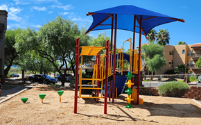 Tucson apartment for rent - a colorful playground in a park with trees in the background