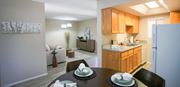 Tucson apartment for rent - A kitchen with wooden cabinets and a dining table set for two.