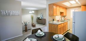 Tucson apartment for rent - A kitchen with wooden cabinets and a dining table set for two.