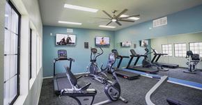 Tucson apartment for rent - A gym with treadmills, exercise bikes, and a television.