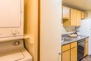 Tucson apartment for rent - laundry room with door and kitchen with wood cabinets