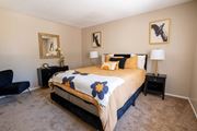 Tucson apartment for rent - A bedroom with a bed, chair, and two lamps.