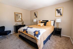 Tucson apartment for rent - A bedroom with a bed, chair, and two lamps.