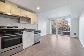 Seattle apartment for rent - a kitchen with white cabinets and stainless steel appliances and a window