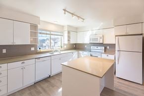 Sumner townhouse for rent - a kitchen with white cabinets and white appliances