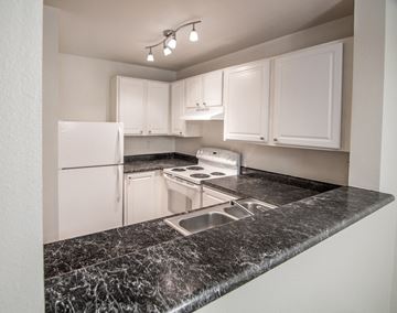 Enumclaw apartment for rent - a kitchen with white cabinets and granite counter tops