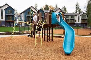 Puyallup townhouse for rent - A playground with a blue slide and a yellow climbing frame.