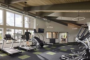 Bremerton apartment for rent - a man is running on a treadmill in a gym with large windows