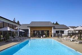 Port Orchard apartment for rent - a swimming pool with lounge chairs and umbrellas in front of a building