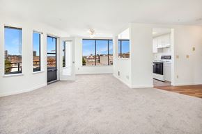 Seattle apartment for rent - an empty living room with a view of a kitchen and a balcony