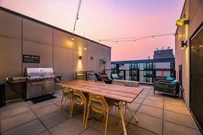 Seattle apartment for rent - A patio with a grill and chairs.