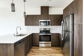 Poulsbo apartment for rent - a modern kitchen with dark wood cabinets and stainless steel appliances