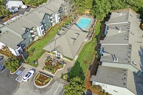 Wilsonville apartment for rent - A bird's eye view of a residential area with houses, a pool, and a parking lot.