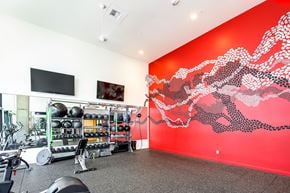 Redmond townhouse for rent - a workout room with a red wall and gym equipment