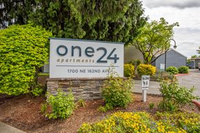 Portland apartment for rent - one 24 apartments sign in front of building with plants and trees