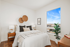 Seattle apartment for rent - A bedroom with a large bed and a window overlooking a cityscape.