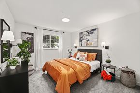 Milton apartment for rent - a bedroom with white walls and an orange bed