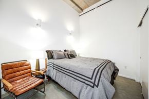 Seattle apartment for rent - A bedroom with a bed, a chair, and a lamp.