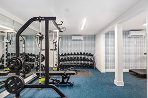 Seattle apartment for rent - A gym with a blue carpet and a variety of equipment.
