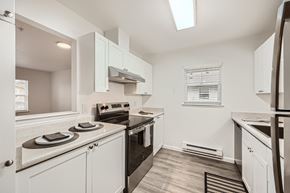 Olympia apartment for rent - A kitchen with white cabinets and appliances.
