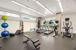 Seattle apartment for rent - a gym with cardio equipment and weights on the floor