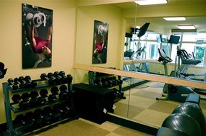 Seattle apartment for rent - A gym with a mirror, weights, and exercise equipment.