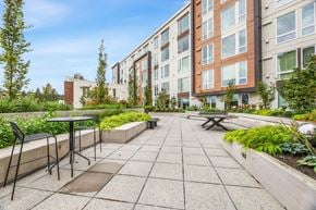 Bellevue apartment for rent - an outdoor patio with a table and chairs in front of an apartment building