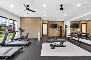 Tacoma apartment for rent - A spacious home gym with treadmills, exercise bikes, and a television.