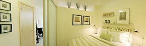 Seattle apartment for rent - A bedroom with a bed, a mirror, and a few pictures on the wall.