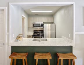 Tacoma apartment for rent - a kitchen with a marble counter top and three wooden stools