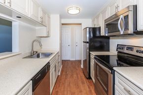 Kirkland apartment for rent - a kitchen with black appliances and white cabinets