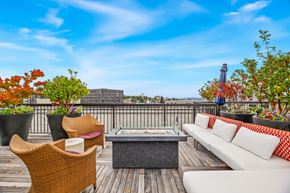 Seattle apartment for rent - a rooftop deck with a couch and chairs and a fire pit