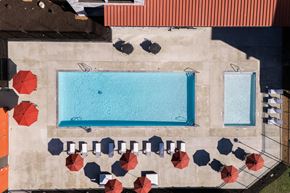 Bend apartment for rent - arial view of a swimming pool with umbrellas and tables on a building