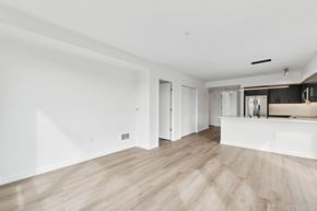Seattle apartment for rent - A spacious room with wooden flooring and white walls.