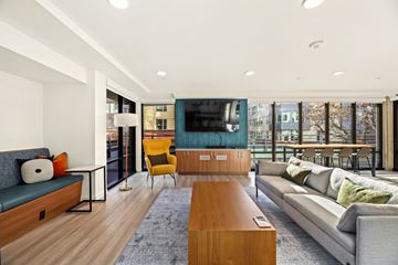 Seattle apartment for rent - A modern living room with a grey sofa, a yellow chair and a wooden coffee table.