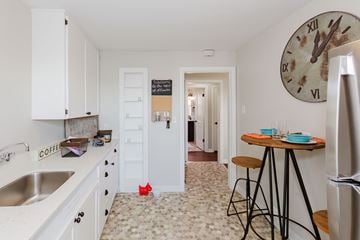 Bremerton apartment for rent - A kitchen with a clock on the wall and a refrigerator on the right.
