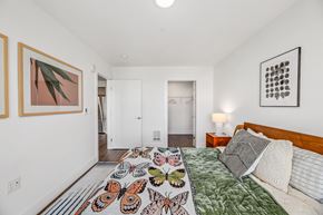 Seattle apartment for rent - a bedroom with white walls and a bed with a colorful comforter