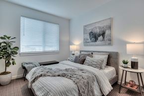 Bend apartment for rent - a bedroom with a bed and a painting of a cow