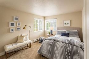 Seattle apartment for rent - A bedroom with a large bed and a bench.