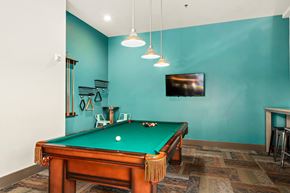Seattle apartment for rent - A pool table in a room with a television mounted on the wall.