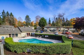 Des Moines apartment for rent - A swimming pool surrounded by a green hedge in a sunny backyard.