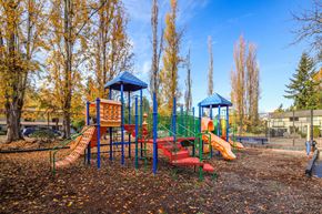 Des Moines apartment for rent - A playground with a red slide and a blue roofed structure.