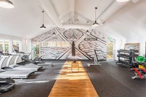 Seattle apartment for rent - A gym with treadmills, elliptical machines, and a wooden floor.