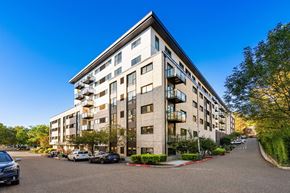 Portland apartment for rent - A large apartment building with a parking lot in front.